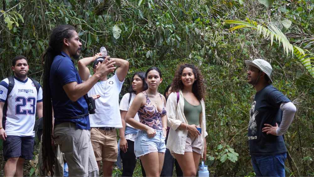 Guía del centro de visitantes y estudiantes en una charla mientras recorren los senderos